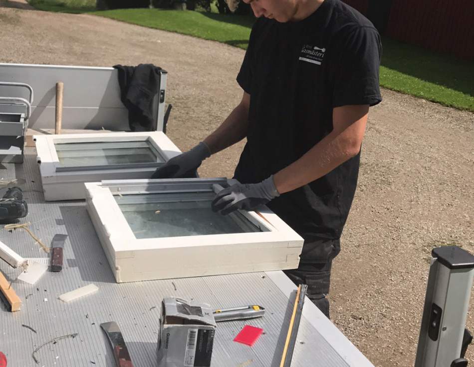 Glasmästare arbetar med en fönsterbåge